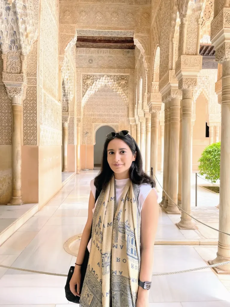 Blogger is standing and smiling in Alhambra, Spain.